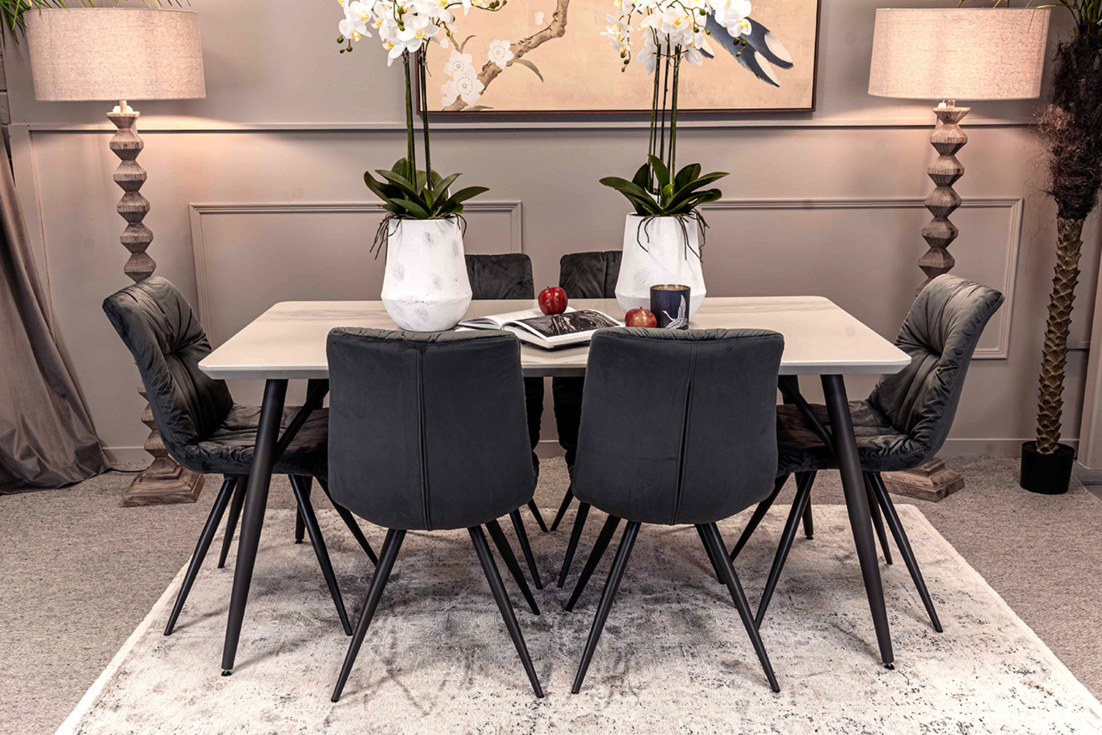 Dining room with a table and chairs, decorative plants, and lamps.