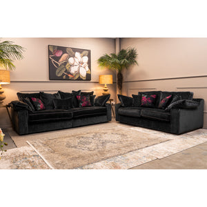 Two dark gray sofas with decorative pillows in a living room setting.